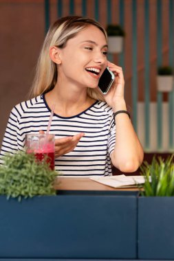 Gülümseyen ve cep telefonu kullanan mutlu bir kızın portresi. İnsanlar teknoloji sosyal ağ kavramı