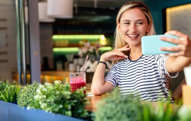 Gülümseyen ve cep telefonu kullanan mutlu bir kızın portresi. İnsanlar teknoloji sosyal ağ kavramı