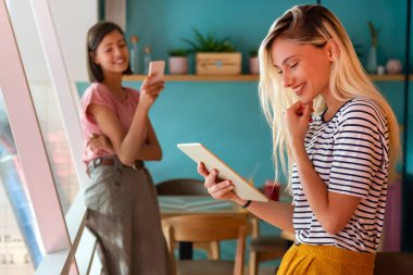 Ofiste tabletle çalışan genç ve mutlu bir kadın. İnsanlar dijital aygıt işletme eğitimi kavramı