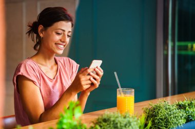 Gülümseyen ve cep telefonu kullanan mutlu bir kızın portresi. İnsanlar teknoloji sosyal ağ kavramı