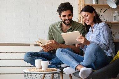 Evde güzel vakit geçiriyorum. Güzel, genç bir çift birbirlerine bağlanıyorlar ve kitap, tablet okurken gülümsüyorlar..