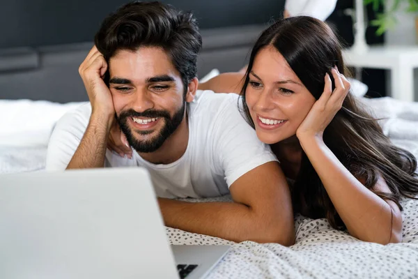 Coppia Felice Con Laptop Letto Leggendo Notizie Sorridendo — Foto Stock