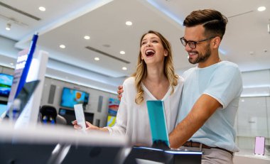 Mobil dükkanından yeni akıllı telefon alan mutlu gençler. Teknoloji Mutluluğu Cihaz Alışverişi