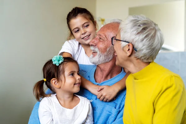 Mutlu büyükanne ve büyükbabalar evde torunlarıyla eğleniyor.