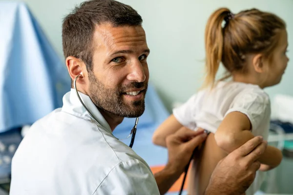 若い医者は入院中の聴診器で少女を調べる 小児科の概念 — ストック写真