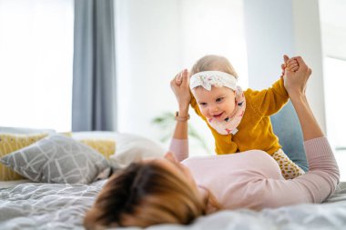 Mutlu bir aile. Anne kız oynuyor, sarılıyor, evde öpüşüyorlar.