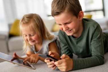 Küçük kız ve oğlan video izliyor ya da dijital cihaz tabletlerinde oyun oynuyorlar, akıllı telefon. Çocuklar dijital bağımlılık kavramı.