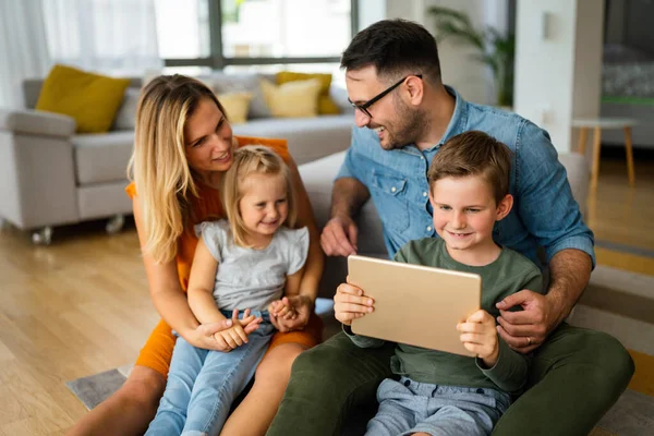 Dijital cihaz teknolojisi aile çevrimiçi eğitim kavramı. Evde dijital cihazları olan mutlu genç bir aile..