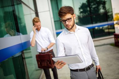 Dışarıda yürüyen iki başarılı iş adamı. İş, arkadaşlık, iletişim konsepti