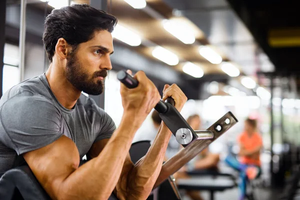 肌肉发达的年轻健美男子在健身房做运动 体育运动人员锻炼概念 — 图库照片