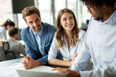 Çok ırklı başarılı iş adamlarından oluşan bir grup ofiste toplanıyor ve fikirlerini paylaşıyor..