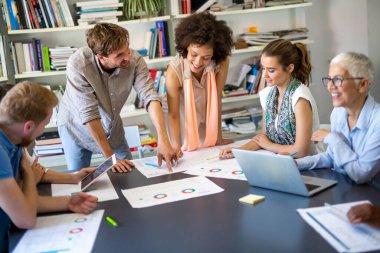 İş ortaklarından oluşan bir grup, şirket ofisinde toplanan belgeler ve fikirleri tartışıyor. Finans insanları takım çalışması kavramı.