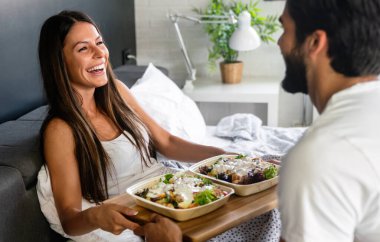 Mutlu adam güzel kız arkadaşı için kahvaltıyı yatağa getirir. Çift, aşk konsepti