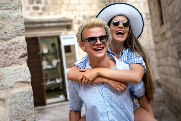 Birkaç turist tatilde şehir caddesinde yürürken eğleniyor. Mutlu arkadaşlar tatilde birlikte gülüyorlar. İnsanlar ve tatil kavramı