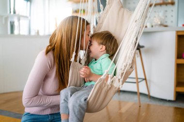 Güzel bir kadın ve küçük oğlu evde oynayıp eğleniyorlar. Mutlu aile kavramı