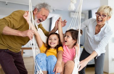 Torunlar eğleniyor, dedelerle evde oynuyorlar. Aile sevgi üretimi konsepti