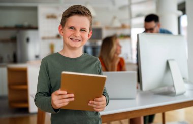 Uzaktan öğrenme, online eğitim, ev işi okulu konsepti. Evde dijital cihazları olan mutlu bir aile.
