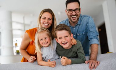 Mutlu genç aile evde eğleniyor. Ebeveynler, çocuklar mutluluk kavramını sever.