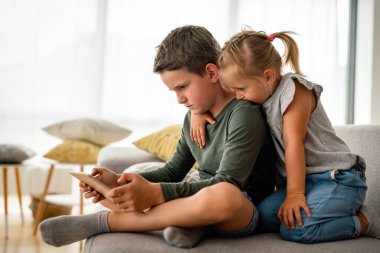 Küçük kız ve oğlan video izliyor ya da dijital cihaz tabletlerinde oyun oynuyorlar, akıllı telefon. Çocuklar dijital bağımlılık kavramı.