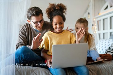 Mutlu bir aile. Baba ve çok ırklı çocuklar evdeki tablette oynuyorlar. Teknoloji, insanlar konsepti