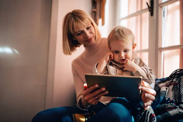 人々の技術家族の幸福の概念 幸せな母親と彼女の子供と一緒に自宅でデジタルタブレットを使用して — ストック写真