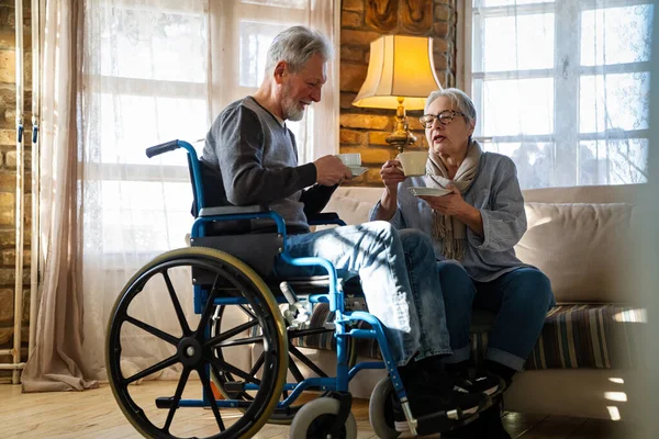 親愛なるご夫婦 車椅子の障害を持つ熟女は 自宅で妻と一緒に時間を過ごす — ストック写真