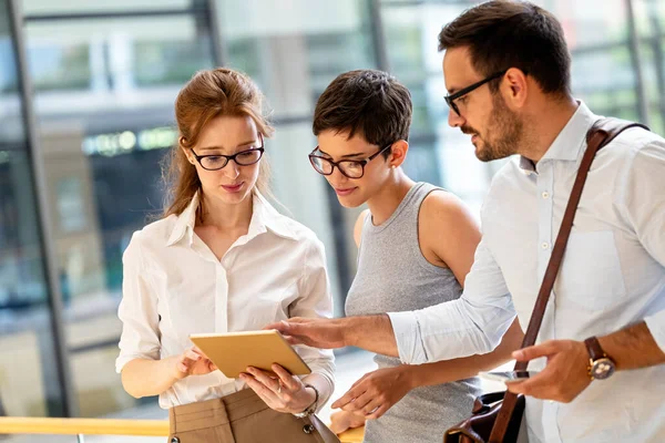 Genç iş adamlarından oluşan mutlu bir grup arkadaş toplantıda fikir alışverişinde bulunuyor. İş takım çalışması konsepti.