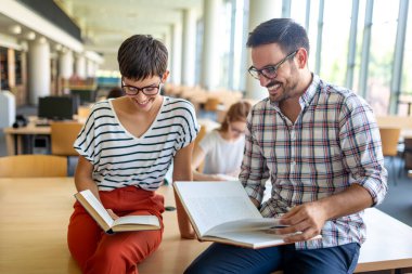 Bir kolej kütüphanesinde birlikte çalışıp çalışan bir grup başarılı öğrenci. Eğitim insanları öğrenme kavramı.