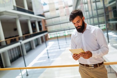 Ofisinde dijital tableti olan başarılı genç iş adamının portresi. İş adamları teknoloji çalışma kavramı