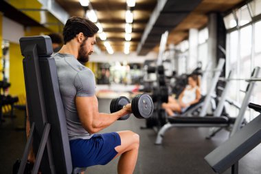 Spor salonunda çalışan formda bir gencin portresi. Spor insanları sağlıklı yaşam tarzı egzersizi konsepti