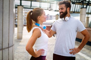 Sağlıklı yaşam tarzının bir parçası olarak dışarıda egzersiz yapan mutlu genç koşucu çift. İnsanlar spor koşusu konsepti