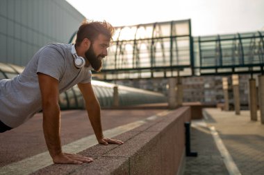 Açık havada egzersiz yapan ve sağlıklı yaşam tarzını seven sağlıklı genç bir adam. Spor dünyasının mutluluk kavramı