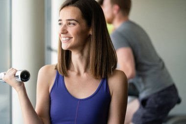 Spor salonundaki çekici, formda genç kadın imajı.