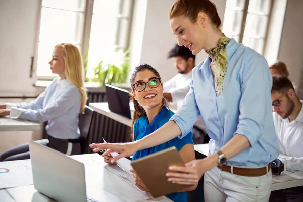 Birlikte yeni bir proje üzerinde çalışıyoruz. Çok ırklı iş adamlarından oluşan mutlu bir grup ofiste bir takım olarak işbirliği yapıyor.