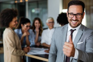 Çok ırklı iş adamlarından oluşan mutlu bir grup ofiste iyi bir işi kutluyor. İş ve finans kavramı.