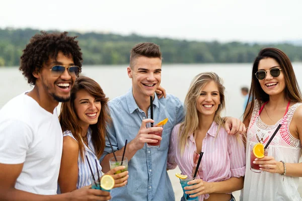一群年轻的朋友在阳光灿烂的海滩上玩得很开心 人们度假快乐饮料的概念 — 图库照片