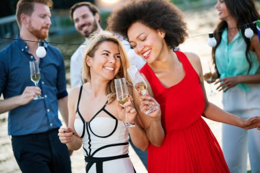 Bir grup mutlu insan ya da arkadaş partide eğleniyor ve gülümsüyor.