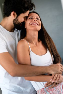 Duygusal ve mutlu bir çift birbirlerine aşık ve evde sarılıyorlar.