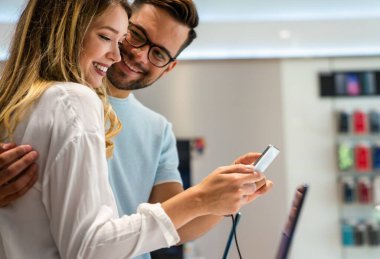 Yeni bir dijital cihaz alıyorum. Mutlu çift mağazadan bir cep telefonu alıyor..