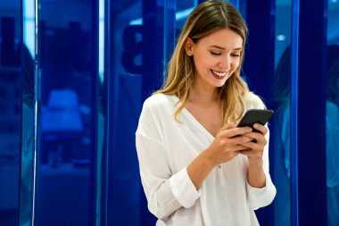 Akıllı telefon kullanan mutlu, gülümseyen iş kadınının portresi. Teknoloji insanları sosyal medya kavramı