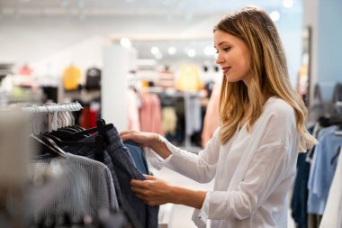 Butikte alışveriş yapan genç ve güzel bir kadının portresi. İnsanlar tüketimcilik mutluluk kavramı.