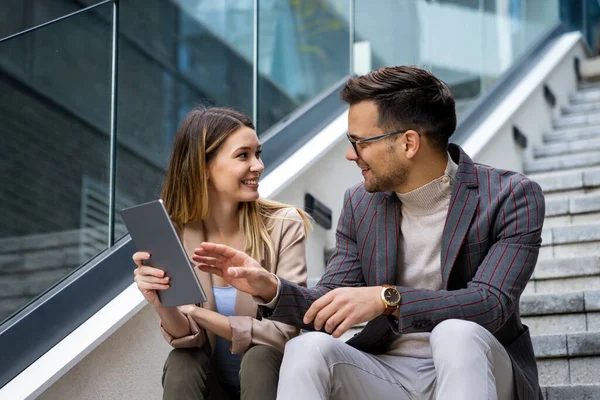 Dijital tablet kullanarak sosyal medya stratejisi üzerinde çalışan iki yaratıcı iş adamı. İş adamları konsept çalışır