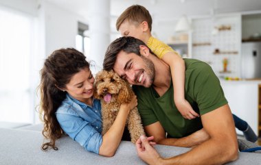 Mutlu bir aile portresi ve evde birlikte eğlenen bir köpek. Mutlu aile kavramı, hayvanları sevmek, çocukluk.