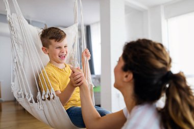 Güzel genç anne oğluyla oynayıp eğleniyor. Evde mutlu bir aile
