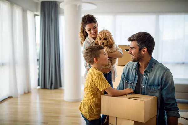 快乐的年轻家庭在新家打开纸板箱 搬进来 新家园的人的概念 — 图库照片