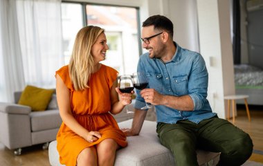 Romantik bir buluşma yaşayan ve şarap içen genç ve mutlu bir çift. Çiftler aşk konseptini sever.