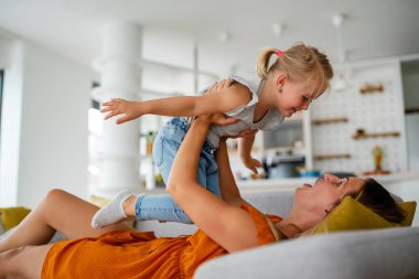 Çocukluk aile kavramına bayılırım. Güzel genç anne ve çocuğu evde birlikte oynuyorlar.