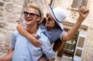 Birkaç turist tatilde şehir caddesinde yürürken eğleniyor. Mutlu arkadaşlar tatilde birlikte gülüyorlar. İnsanlar ve tatil kavramı