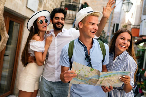 Happy traveling student tourists sightseeing with map in hand