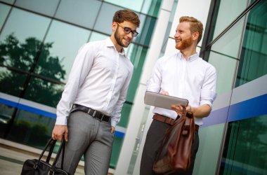 Two successful businessmen walking outdoor. Business, friendship, communication concept